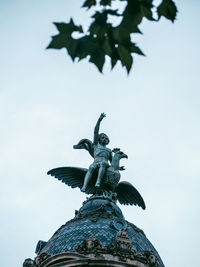 Low angle view of angel statue against sky