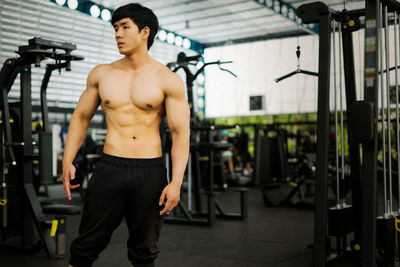 Shirtless man standing at gym