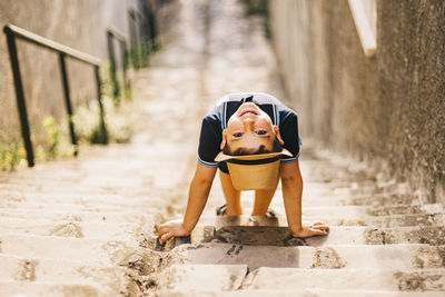 High angle portrait of cute boy wearing hat standing on steps