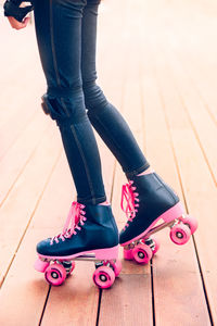 Low section of teenage girl roller skating on boardwalk