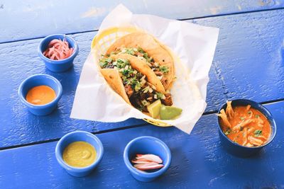 High angle view of taco with sauce and salad served on table