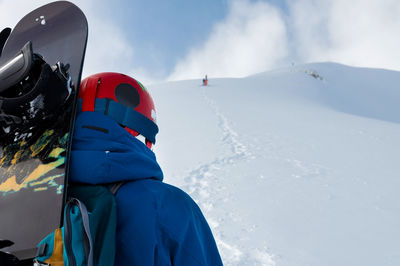 Rear view of man standing on snow covered landscape