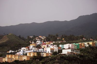 Town by mountains against clear sky