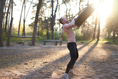 Shirtless young man exercising outdoors