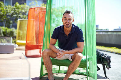 A man sitting in a colorful chair on a modern patio.