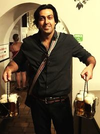 Young man wearing sunglasses standing against glass