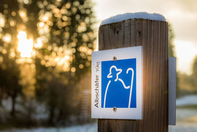 Information sign on wooden post during winter