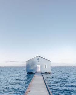 Built structure by sea against clear sky