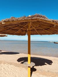 Lifeguard hut on beach against clear blue sky