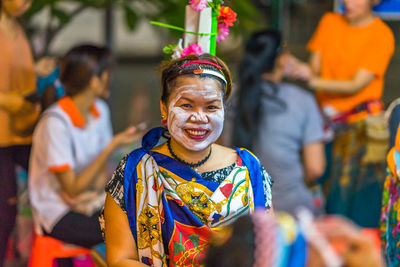 Portrait of smiling woman in costume wearing facial mask
