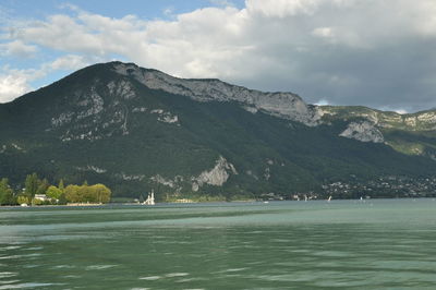 Scenic view of sea and mountains against sky