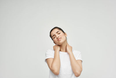 Portrait of a smiling young woman against white background