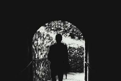 Rear view of silhouette man standing in corridor