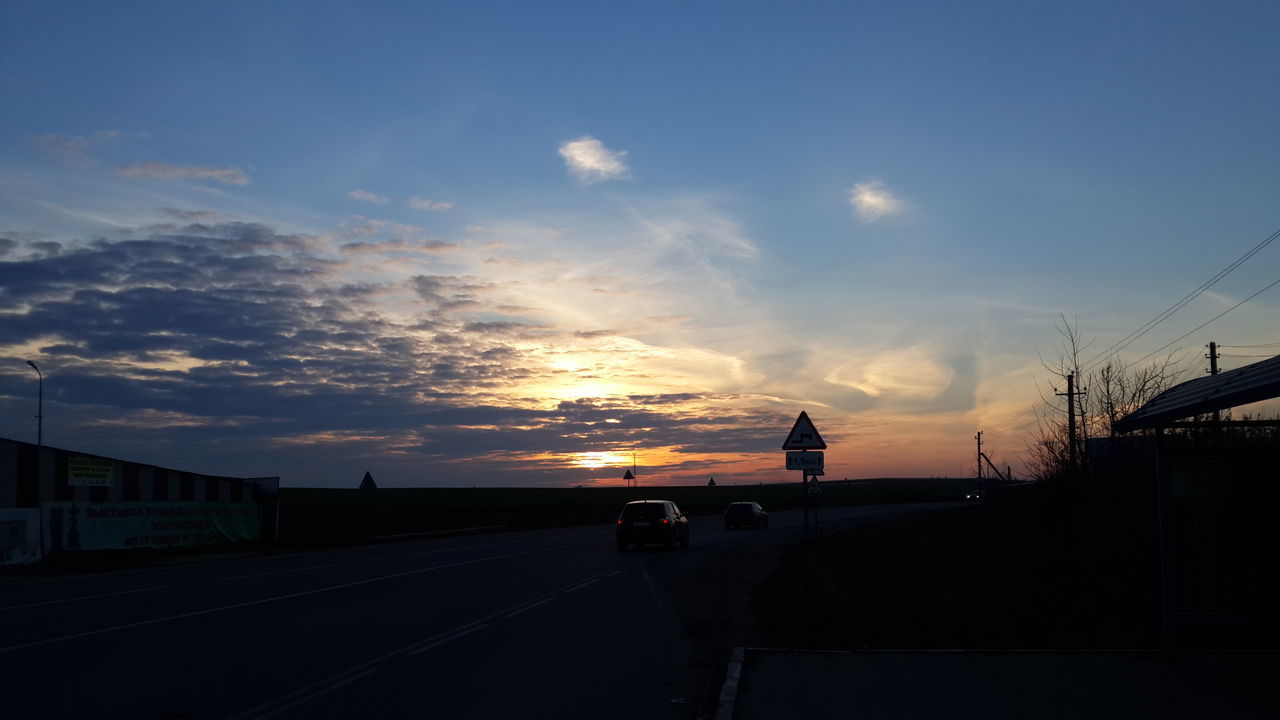 sunset, sky, transportation, sun, silhouette, road, cloud - sky, car, orange color, sunlight, the way forward, land vehicle, street, cloud, sunbeam, scenics, road marking, beauty in nature, nature, mode of transport