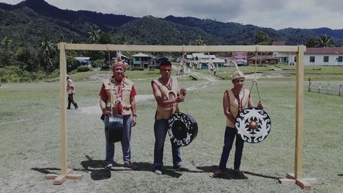 Portrait of people standing on field against mountain