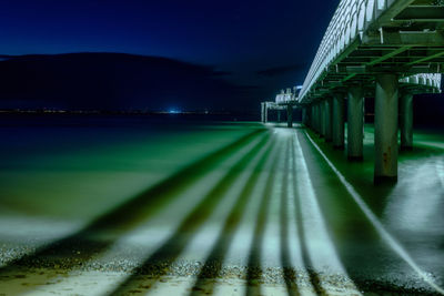 Illuminated bridge against sky at night