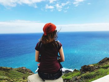 Rear view of woman looking at sea against sky