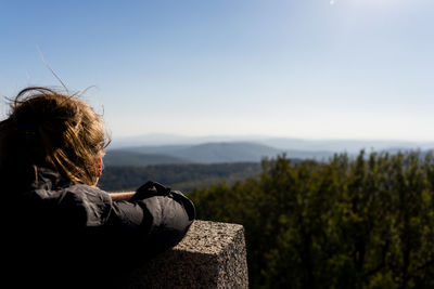 Rear view of woman looking at mountain against sky