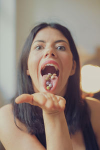 Close-up portrait of woman taking medicines at home