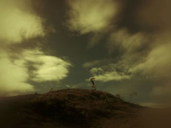 Man standing on rock against sky