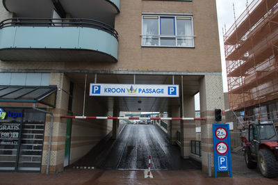 Information sign on road amidst buildings in city