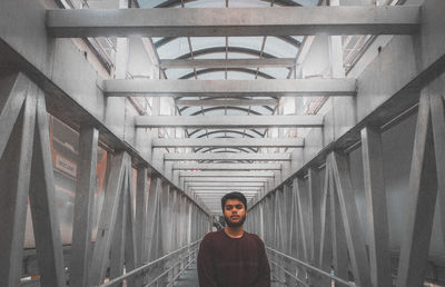 Portrait of young man standing on railing