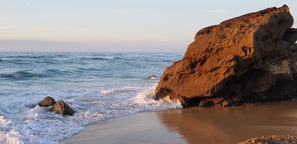 Scenic view of rocky beach against sky