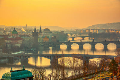 Prague bridges panorama during mist fog morning sunrise warm light red sky