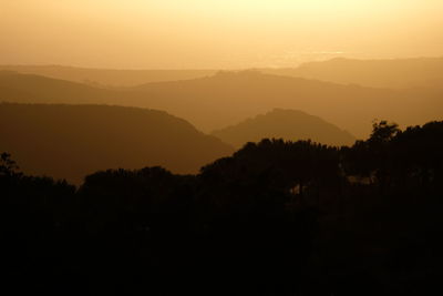 Scenic view of silhouette mountains against sky at sunset