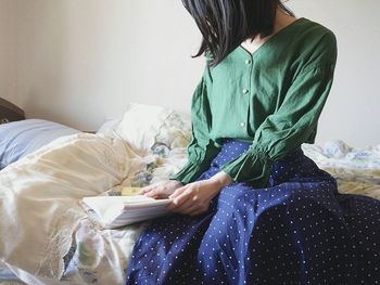 Woman sitting on bed at home