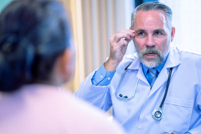 Side view of doctor examining patient at home