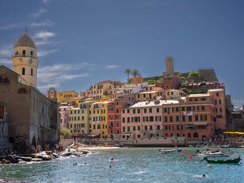 Buildings by river against sky