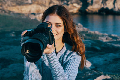 Portrait of woman photographing water