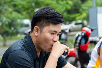 Close-up of man smoking electronic cigarette outdoors