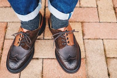 Low section of man standing on footpath