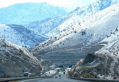 Vehicles on road by mountain against sky