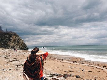 Rear view of woman looking at sea against sky