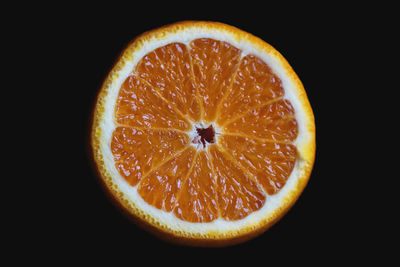 Close-up of orange slices over black background