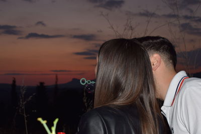 Rear view of couple against sky during sunset