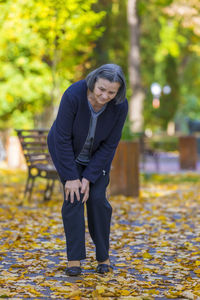 Full length of senior woman with injured knees standing at park