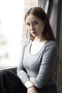 Portrait of young woman sitting at home