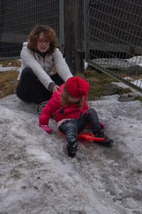 Full length of boy sitting on snow