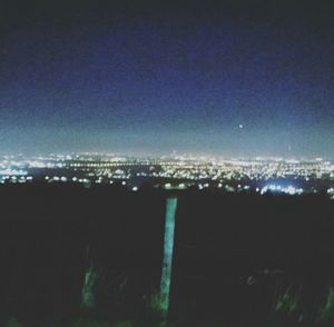 Illuminated cityscape against sky at night