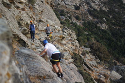 Rear view of friends standing on rock