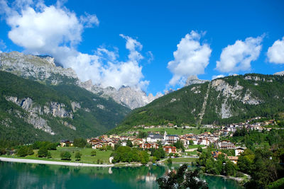 Scenic view of townscape by mountains against sky