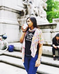 Full length of a young woman drinking glass