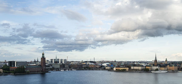 Buildings in city against cloudy sky