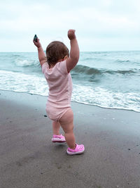 Rear view of baby girl on beach