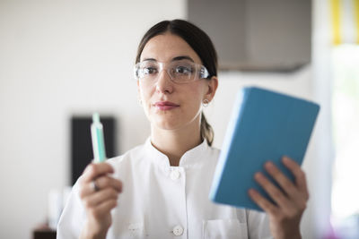 Scientist female with lab glasses, tablet and sample in a lab