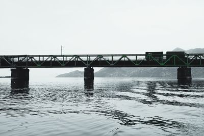 Bridge over sea against clear sky